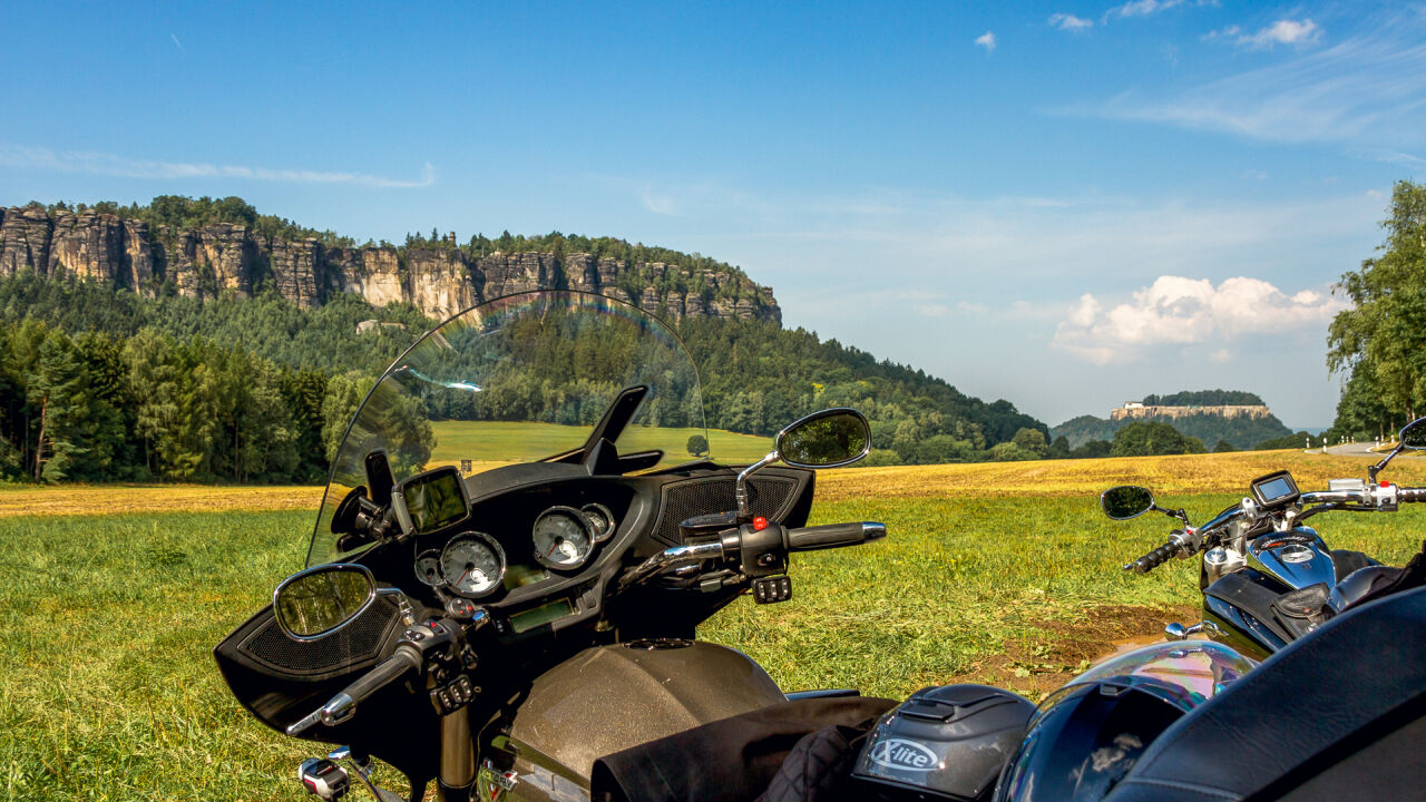 Lenker eines Tourenmotorrads im Vordergrund, dahinter ein langgestreckter Tafelberg mit Felswänden Lenker eines Tourenmotorrads im Vordergrund, dahinter ein langgestreckter Tafelberg mit Felswänden